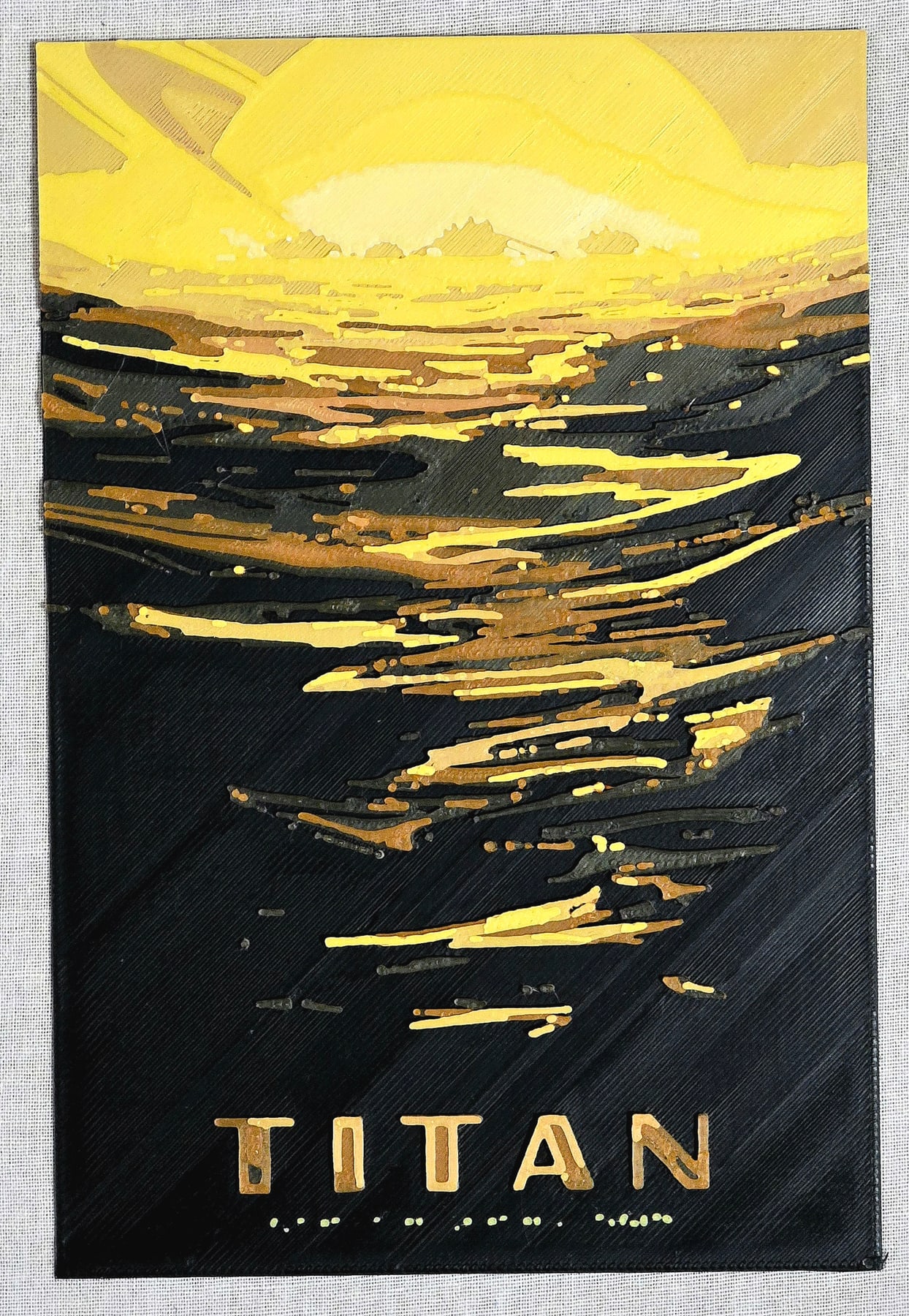 Titan layered print, with a yellow sun above a dark landscape and TITAN lettering at the bottom